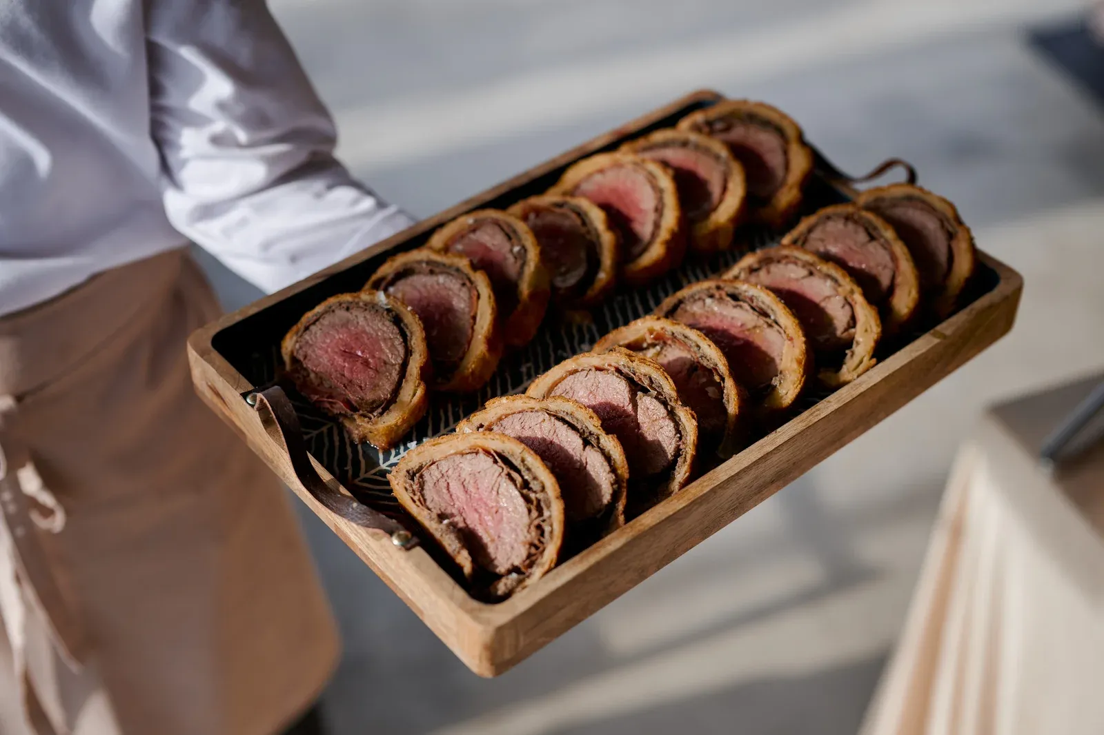 Sliced beef Wellington on wooden tray
