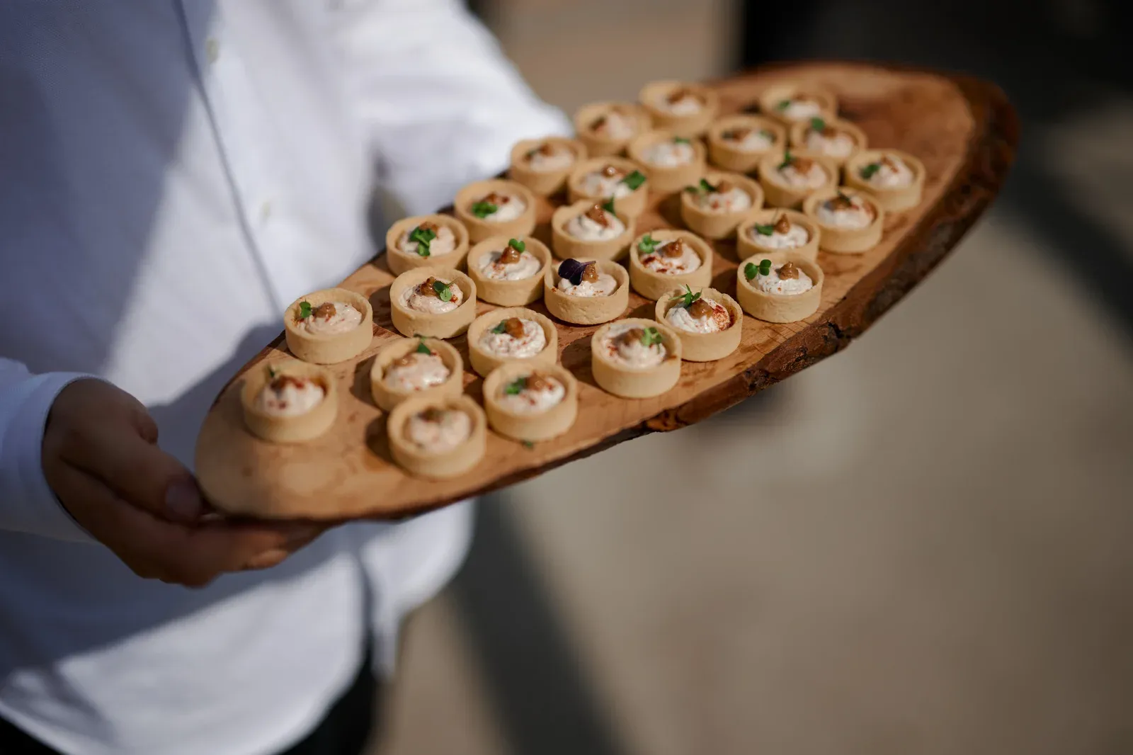 Canapé tartlets on olive wood board